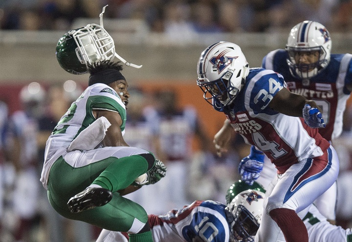 Saskatchewan Roughriders running back Cameron Marshall loses his helmet as he is rushed by Montreal Alouettes linebacker Kyries Hebert during third quarter CFL football action in Montreal on Thursday, June 22, 2017. THE CANADIAN PRESS/Paul Chiasson