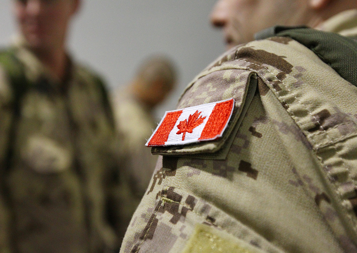 The Canadian flag is seen on the shoulder of a soldier waiting to board an Airbus CC-150 Polaris at CFB Trenton in Trenton, Ont., on Oct. 16, 2014.