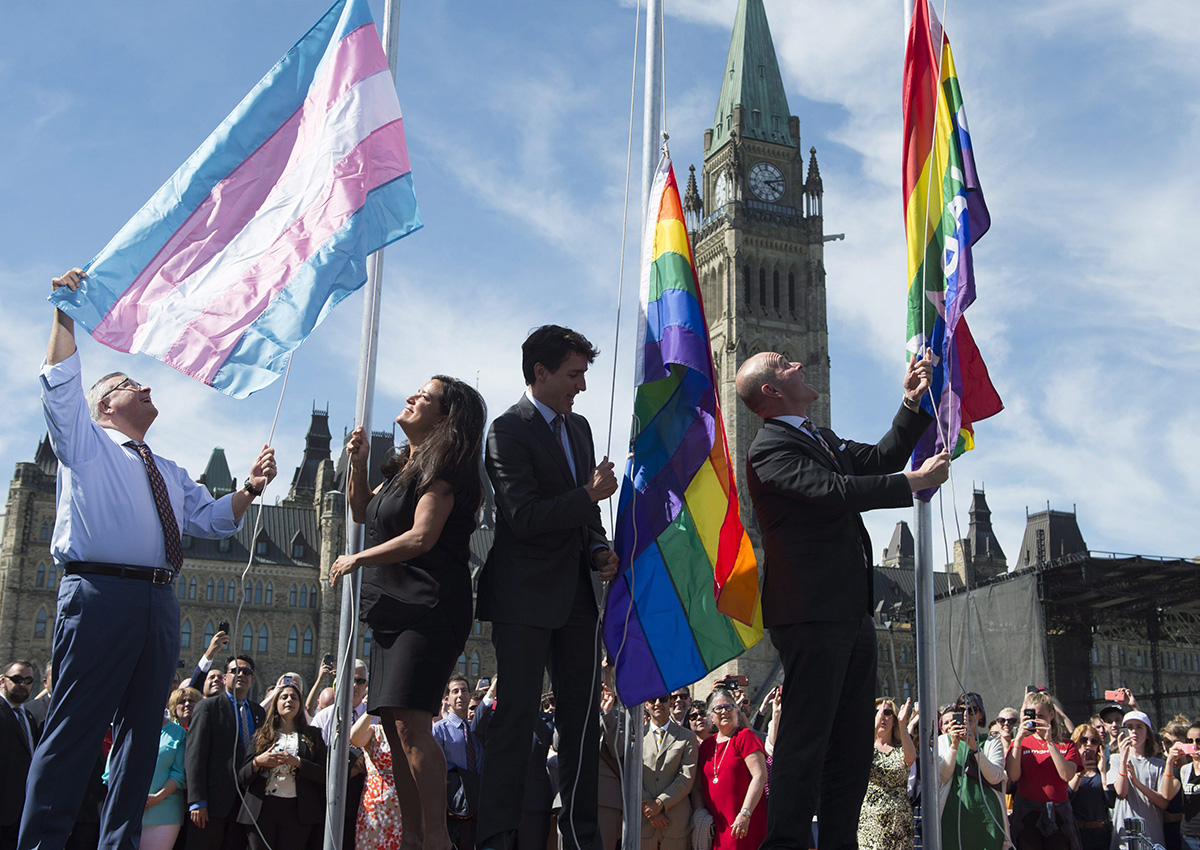 Public Safety and Emergency Preparedness Minister Ralph Goodale(left), Minister of Justice and Attorney General of Canada Jody Wilson-Raybould, Canadian Prime Minister Justin Trudeau and Liberal MP Randy Boissonnault raise the pride and transgender flags on Parliament Hill in Ottawa, Wednesday June 14, 2017. 