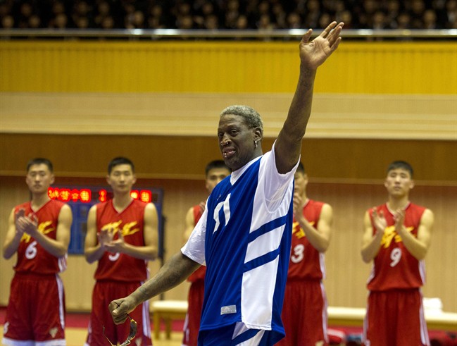 In this Jan. 8, 2014, file photo, Dennis Rodman waves to North Korean leader Kim Jong Un, seated above in the stands, after singing Happy Birthday to Kim before an exhibition basketball game with U.S. and North Korean players at an indoor stadium in Pyongyang, North Korea.
