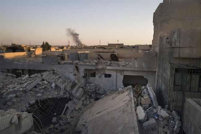 An Iraqi soldier stands atop a destroyed house in a neighborhood recently retaken by Iraqi security forces during fighting against Islamic State militants in west Mosul, Iraq, Sunday, June 25, 2017. 