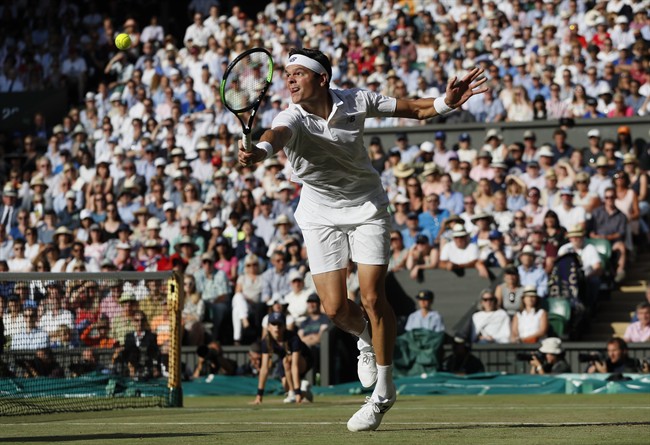 Canada's Milos Raonic returns to Switzerland's Roger Federer during their Men's Singles Quarterfinal Match on day nine at the Wimbledon Tennis Championships in London Wednesday, July 12, 2017.