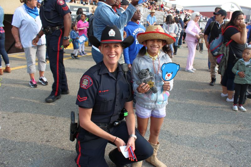Ashlynn (right) and her teddy bear given to her by Officer Mattice (left) from the Calgary Police Service at the 2017 Calgary Stampede. 