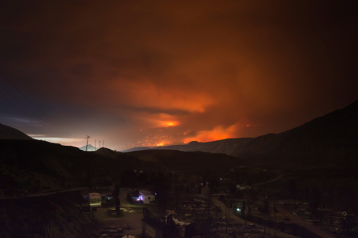 A wildfire burns on a mountain east of Cache Creek near a trailer park that was nearly destroyed by wildfire, in Boston Flats, B.C., July 10, 2017.