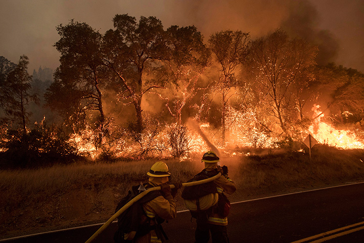 Firefighters work to contain a wildfire as it threatens to jump a road near Oroville, Calif., on Saturday, July 8, 2017.