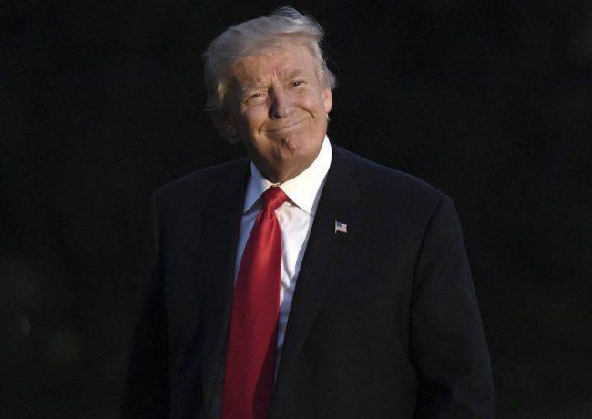 Donald Trump smiles as he returns to the White House.
