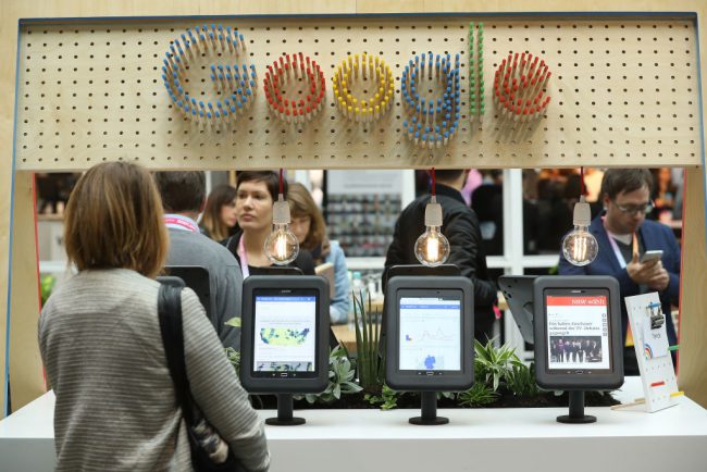 A visitor taps through news on a tablet at the Google Digital News Initiative stand at the Re:publica 17 conference on digital society in Berlin, Germany, May 8, 2017.