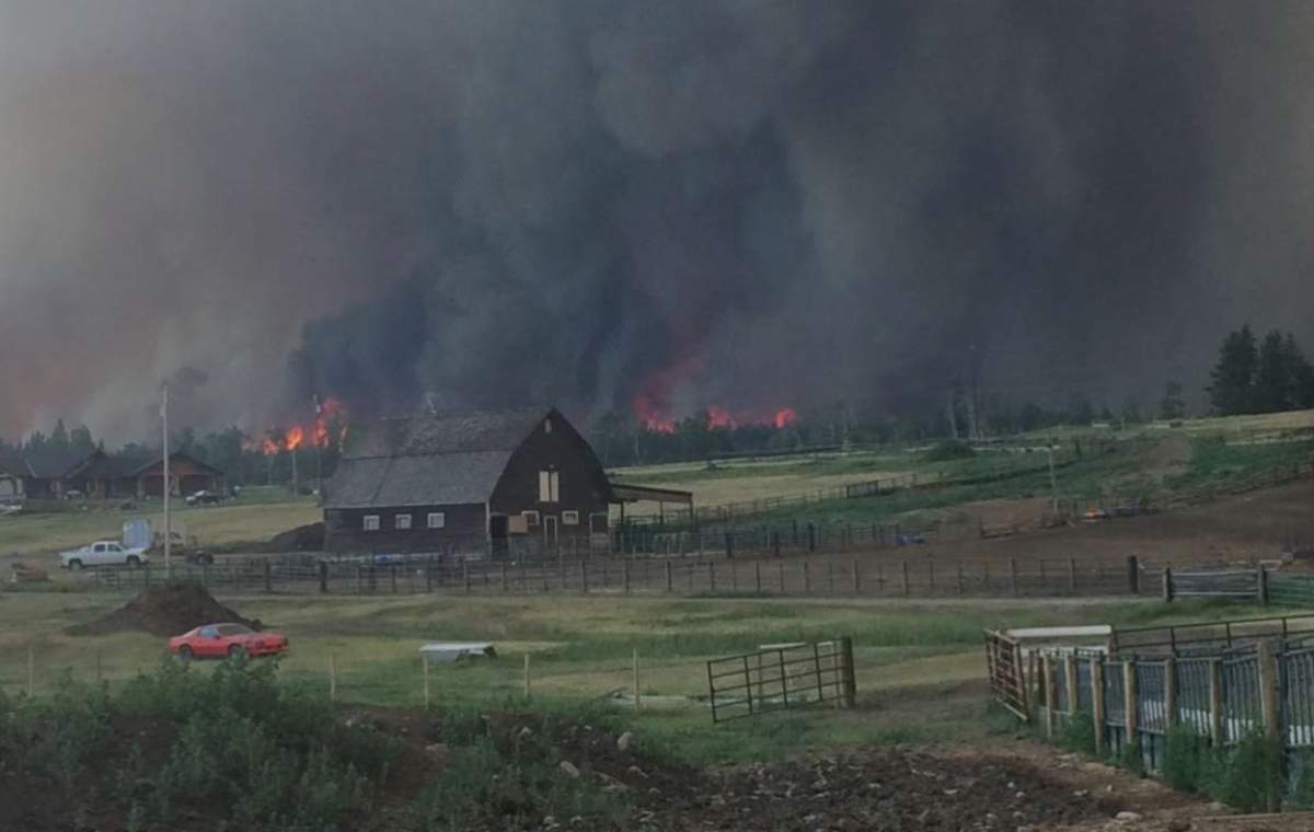 Wildfires burn behind a ranch near 100 Mile House.