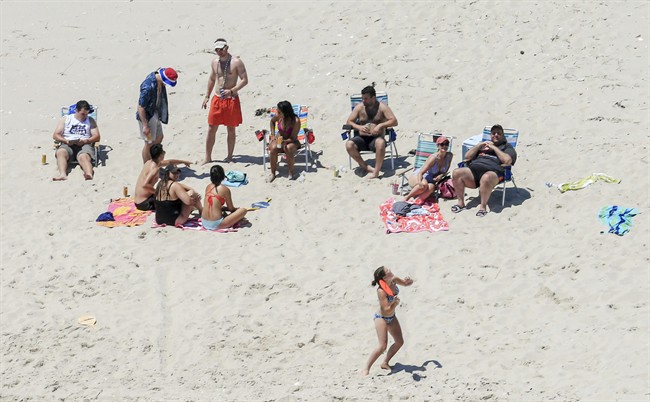 In this Sunday, July 2, 2017, photo, New Jersey Gov. Chris Christie, right, uses the beach with his family and friends at the governor’s summer house at Island Beach State Park in New Jersey.