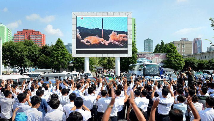 People watch a huge screen showing the test launch of intercontinental ballistic missile Hwasong-14 in this undated photo released by North Korea’s Korean Central News Agency, July 5, 2017.