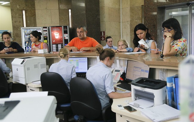 In this photo taken Wednesday, July 5, 2017, patients stand at the reception in a private clinic in Kiev, Ukraine. The clinic was one of many institutions disrupted by June 27 cyberattack which paralysed computers in Ukraine and across the globe. (AP Photo/Efrem Lukatsky).