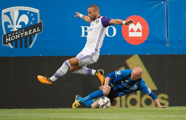 Orlando City SC midfielder Scott Sutter leaps to avoid Montreal Impact defender Laurent Ciman during first half MLS action Saturday, August 5, 2017 in Montreal.