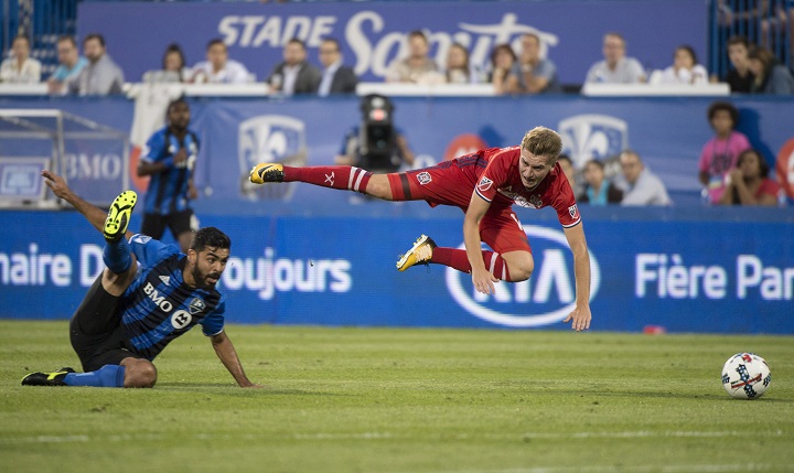 Chicago Fire midfielder Djordje Mihailovic trips over Montreal Impact defender Victor Cabrera during first half MLS action Wednesday, August 16, 2017 in Montreal. THE CANADIAN PRESS/Paul Chiasson