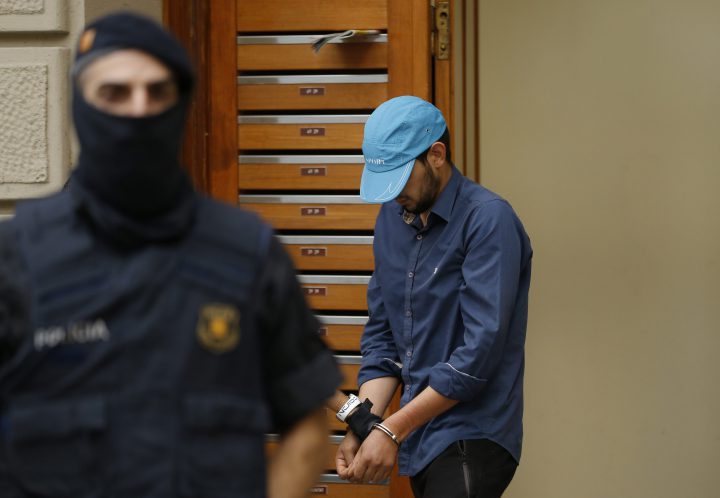 A suspect is led out of a building by police in Ripoll, north of Barcelona, Aug. 18, 2017.
