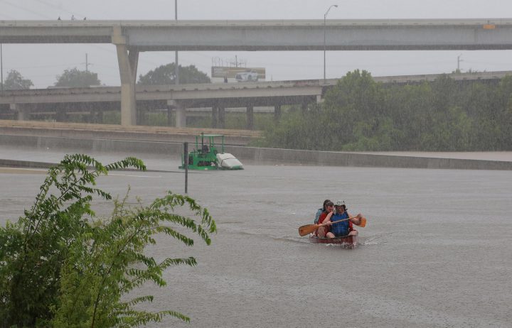 Area residents use a kayak to rescue motorists stranded on Interstate highway 45 which is submerged from the effects of Hurricane Harvey seen during widespread flooding in Houston, Texas, U.S. August 27, 2017. REUTERS/Richard Carson