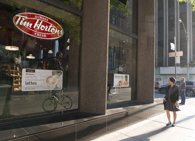 A woman walks pass a Tim Hortons in Toronto on Wednesday Aug. 2, 2017. Restaurant Brands International Inc. (TSX:QSR) says it has signed a deal with joint venture partner to take Tim Hortons to Spain. 