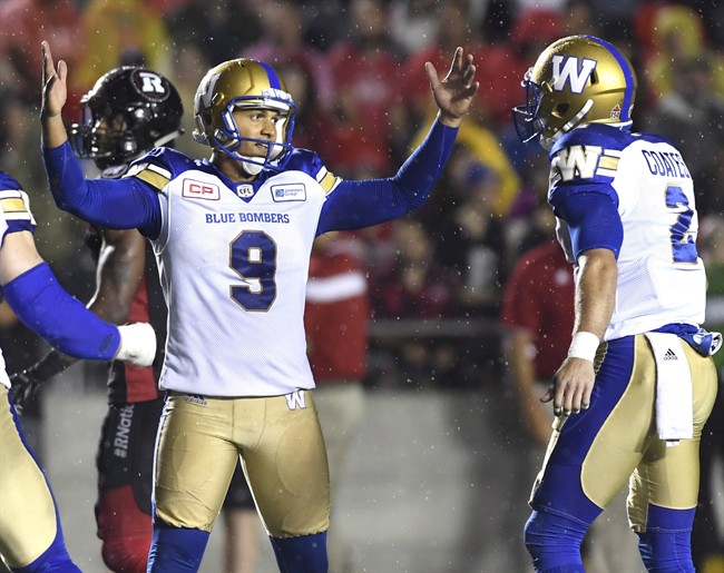 Winnipeg Blue Bombers kicker Justin Medlock raises his hands as he celebrates his game winning field goal against the Ottawa Redblacks.