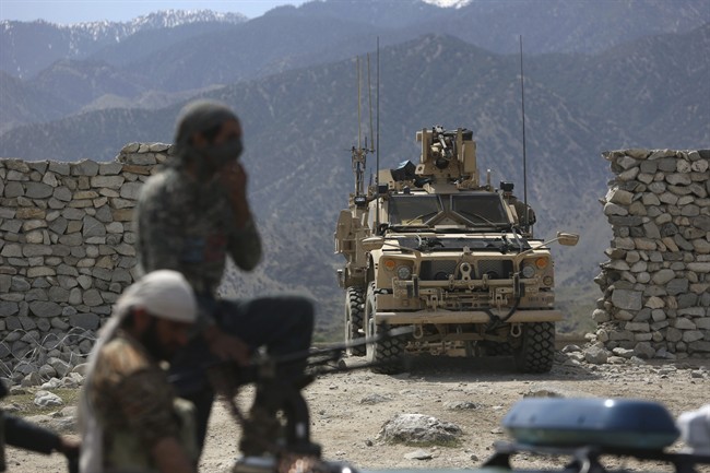 In this April 17, 2017 file photo, U.S. forces and Afghan security police are seen in Asad Khil near the site of a U.S. bombing in the Achin district of Jalalabad, east of Kabul, Afghanistan.