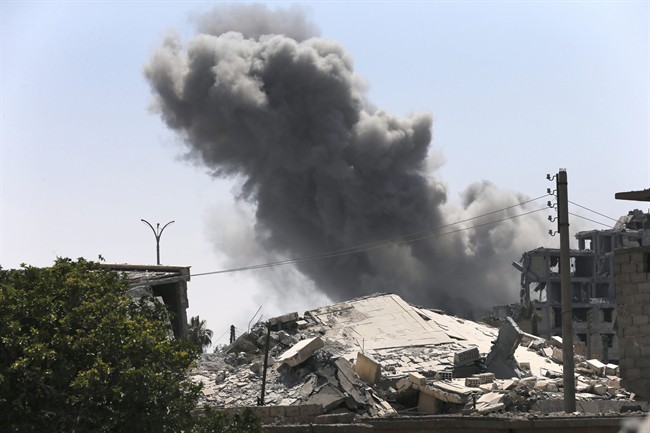 In this July 26, 2017 file photo, black smoke rises from a coalition airstrike which attacked an Islamic State militant position, on the front line on the eastern side of Raqqa, Syria.