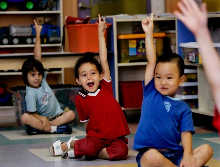 In this file photo, Children put up their hands for ice cream at a daycare centre in Montreal. Workers in subsidized daycare centres across the province voted in favour of a six-day strike mandate. Thursday, Sept. 28, 2017.
