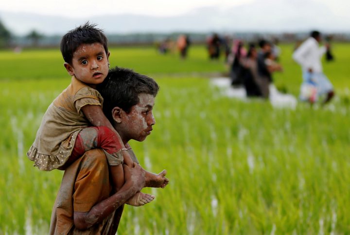 A Rohingya boy carries a child after after crossing the Bangladesh-Myanmar border in Teknaf, Bangladesh, Sept. 1, 2017.