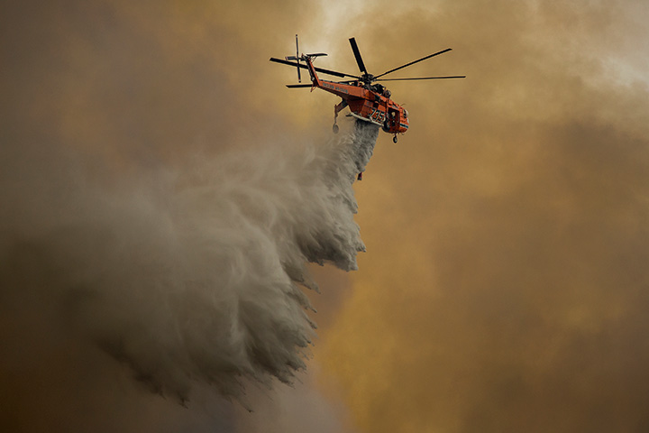 An Erickson Air Crane firefighting helicopter drops water over the La Tuna Fire on September 2, 2017 near Burbank, California.