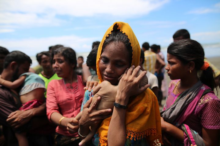 A Rohingya Muslim woman holds an infant child who died when the boat they were traveling in capsized.