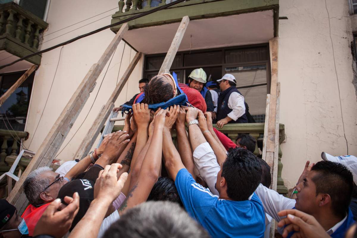 MEXICO CITY, MEXICO – SEPTEMBER 19: Rescuers and residents assists an injured victim amid the ruins of a building knocked down by a magnitude 7.1 earthquake that jolted central Mexico damaging buildings, knocking out power and causing alarm throughout the capital on September 19, 2017 in Mexico City, Mexico. The earthquake comes 32 years after a magnitude-8.0 earthquake hit on September 19, 1985. (Photo by Pedro Mera/Getty Images)