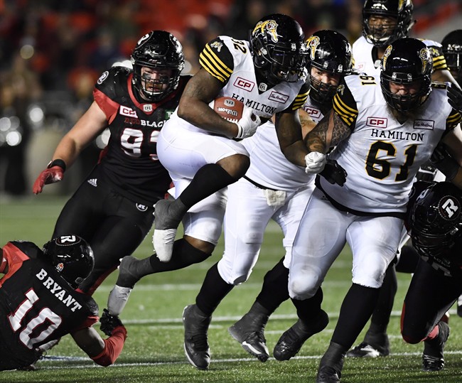 Hamilton Tiger-Cats' C.J. Gable (32) leaps past Ottawa Redblacks' Sederius Bryant (10) as he runs with the ball during second half CFL football action against the Ottawa Redblacks, in Ottawa on Saturday, Sept. 9, 2017.
