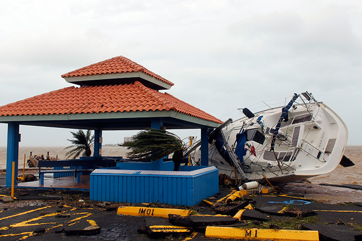 A sail boat lies over a pier in Fajardo as Hurricane Maria hits Puerto Rico on September 20, 2017.