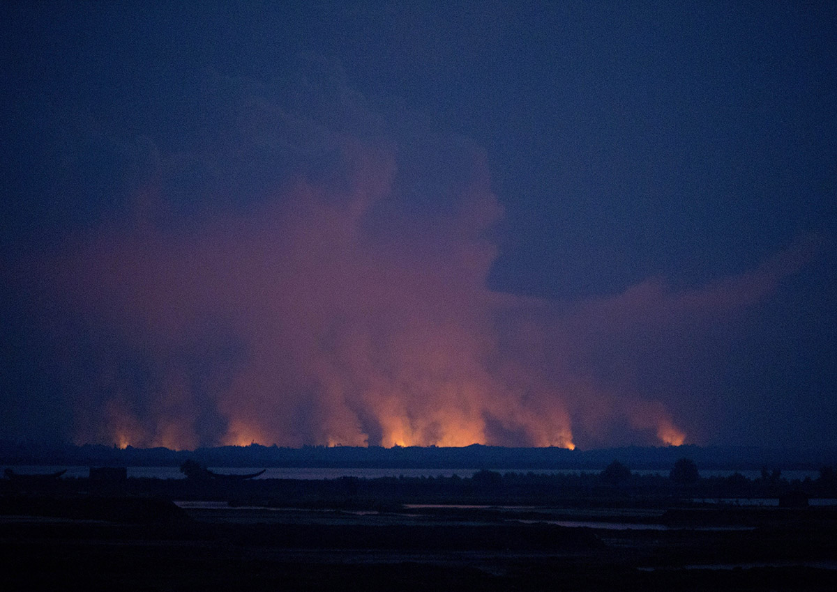 In this Sept. 3, 2017, file photo, smoke and flames in Myanmar are visible from the Bangladeshi side of the border near Cox's Bazar's Teknaf area.
