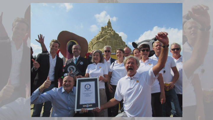 The team that constructed the world’s tallest sandcastle holds their certificate from Guinness World Records.