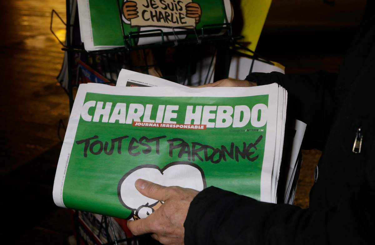 In this Wednesday, Jan. 14, 2015, file photo, a seller of newspapers stocks several Charlie Hebdo newspapers at a newsstand in Nice, France. Under armed security and a cloud of conflicted opinions and emotions, the French satirical magazine Charlie Hebdo was presented a freedom of expression award on Tuesday, May 5, 2015, in New York, from the PEN American Center.