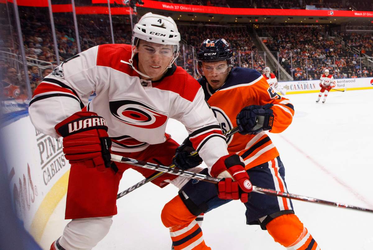 Carolina Hurricanes' Haydn Fleury (4) and Edmonton Oilers' Kailer Yamamoto (56) battle in the corner during second period NHL action in Edmonton, Alta., on Tuesday October 17, 2017. 