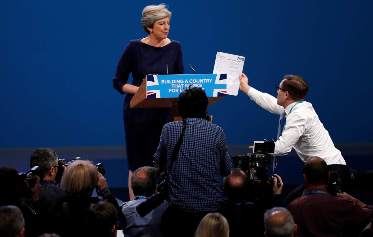 A member of the audience hands a P45 form (termination of employment tax form) to Britain’s Prime Minister Theresa May as she addresses the Conservative Party conference in Manchester, October 4, 2017.