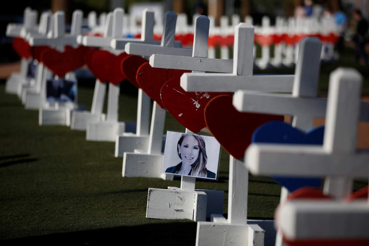 A photograph hangs from one of the 58 white crosses set up for the victims of the Route 91 music festival mass shooting in Las Vegas, Nevada, U.S., October 5, 2017. REUTERS/Chris Wattie.