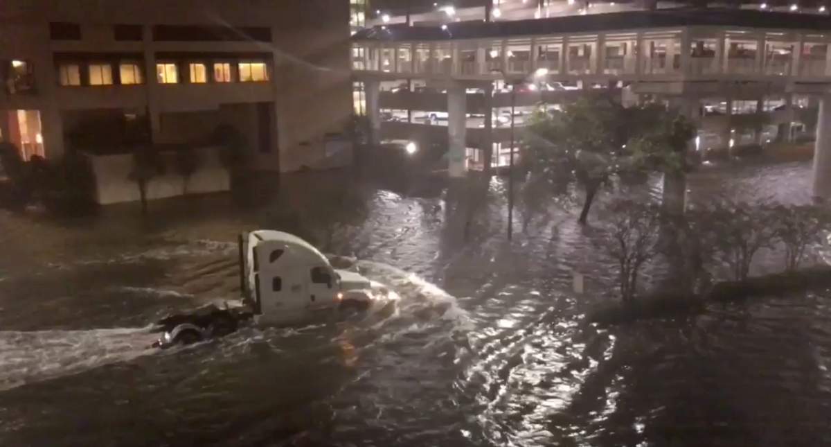 A vehicle drives through a flooded street in Mobile, Ala., on Oct. 8, in this still image taken from a video obtained from social media.