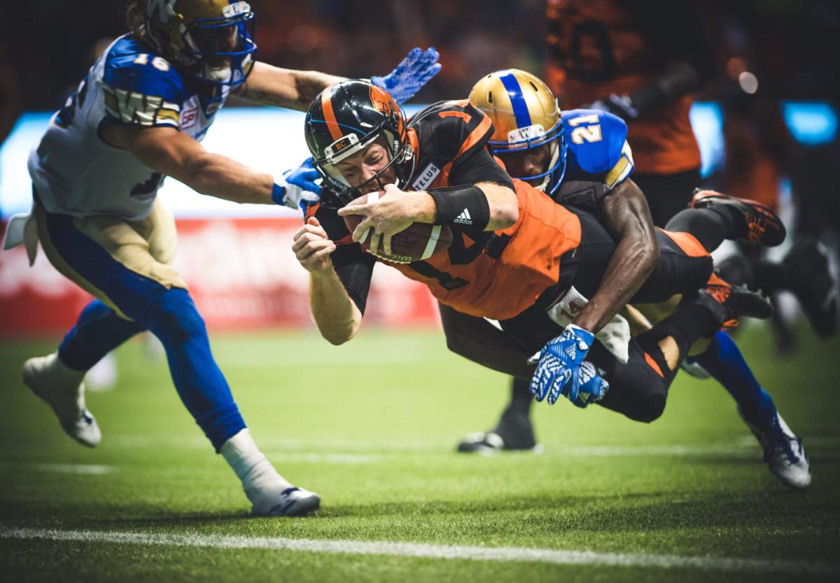 Travis Lulay (14) of the BC Lions and Brandon Alexander (21) of the Winnipeg Blue Bombers during the game at BC Place Stadium in Vancouver, BC., on Friday, July 21, 2017. (Photo: Johany Jutras)