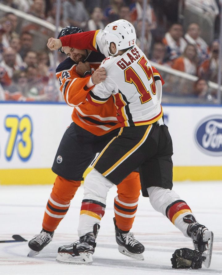 Calgary Flames’ Tanner Glass (15) and Edmonton Oilers’ Zack Kassian (44) fight during first period NHL action in Edmonton, Alta., on Wednesday October 4, 2017.