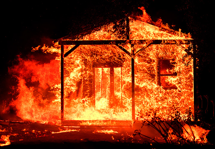 Flames overtake a structure as nearby homes burn in the Napa wine region in California on October 9, 2017.