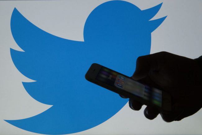 ANKARA, TURKEY - MARCH 16: A picture shows a man holding a cellphone in front of a twitter logo in Ankara, Turkey on March 16, 2017.