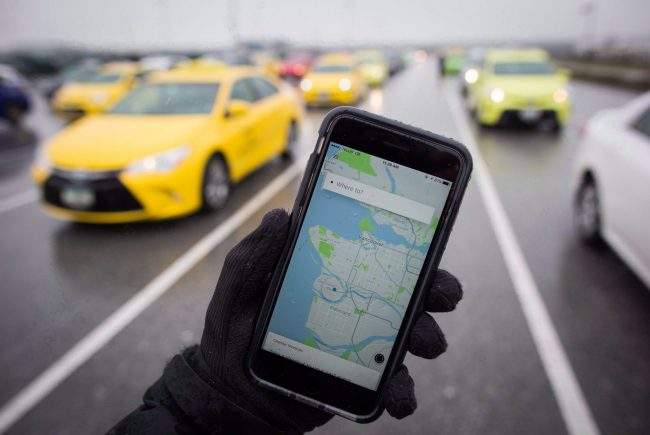 The Uber app is displayed on an iPhone as taxi drivers wait for passengers at Vancouver International Airport, in Richmond, B.C., on Tuesday, March 7, 2017.