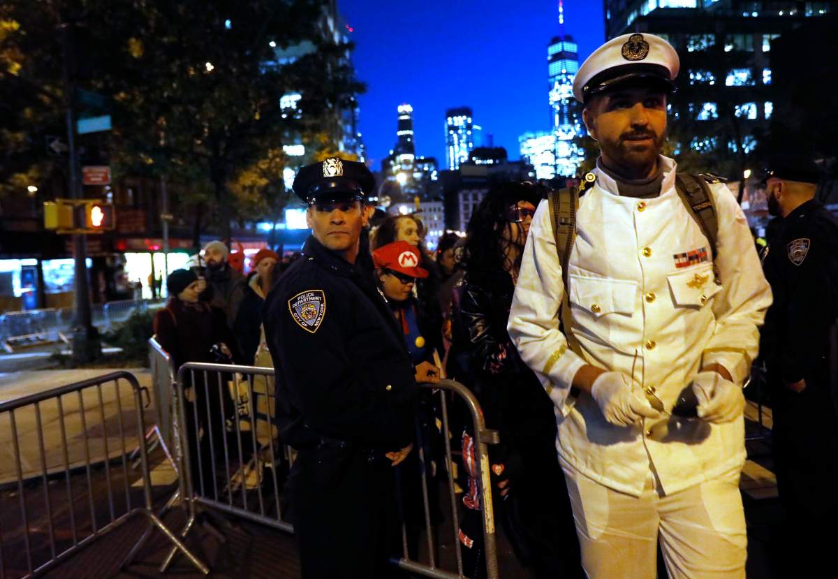 A man in costume (R) passes a police officer at a barricade as he enters the New York City Halloween parade, after a shooting incident blocks away in New York City, U.S. October 31, 2017.