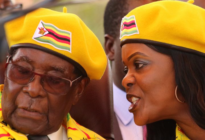 President Robert Mugabe listens to his wife Grace Mugabe at a rally of his ruling ZANU(PF) party in Harare, Zimbabwe, Nov. 8, 2017.