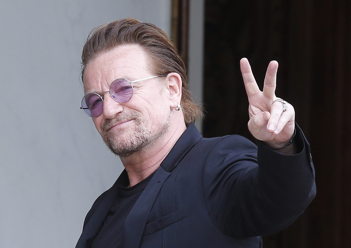 In this Monday, July 24, 2017 file photo, U2 singer Bono makes a peace sign as he arrives for a meeting at the Elysee Palace, in Paris, France. 