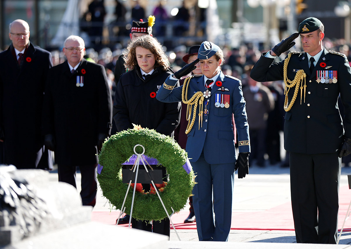 Canada’s Governor General Julie Payette (2nd R) salutes after laying a wreath with her son Laurier Payette Flynn (L) during Remembrance Day ceremonies at the National War Memorial in Ottawa, on Nov. 11, 2017.