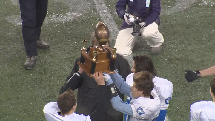The Oak Park Raiders hoist the championship trophy after winning the Home Run Sports Bowl for the junior varsity title.