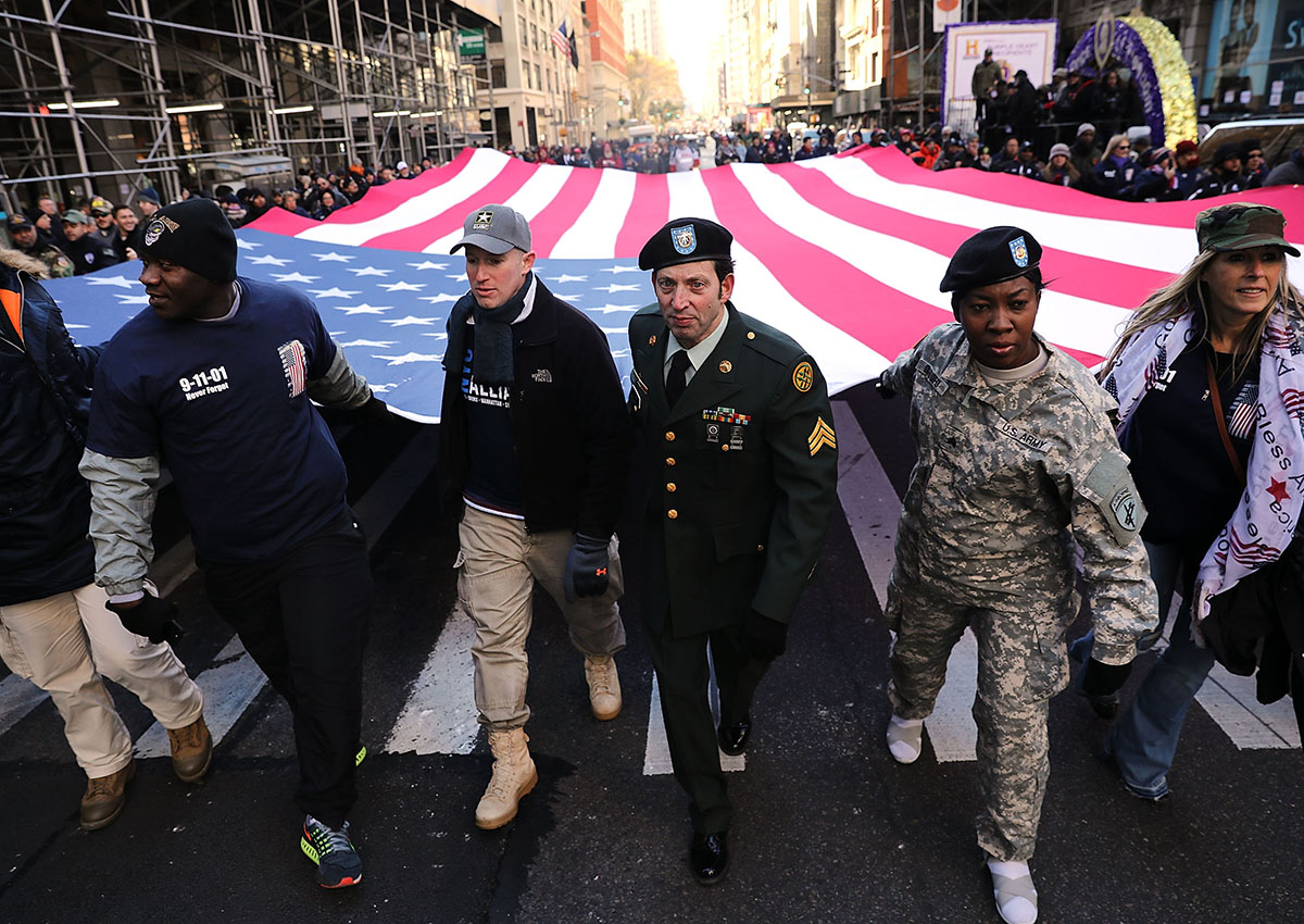 : Soldiers, veterans and civilians carry an American Flag as they march in the Veterans Day Parade on November 11, 2017 in New York City. The largest Veterans Day event in the nation, this year’s parade features thousands of marchers, including military units, civic and youth groups, businesses and high school bands from across the country and veterans of all eras. The U.S. Air Force is this year’s featured service and the grand marshal is space pioneer Buzz Aldrin.