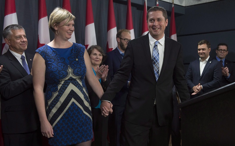 Andrew and Jill Scheer leave an announcement surrounded by Members of Parliament Wednesday September 28, 2016 in Ottawa. THE CANADIAN PRESS/Adrian Wyld