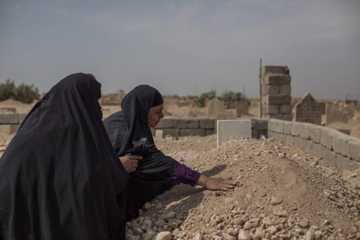 Fatima Ahmed Aswad cries as she touches the grave of her 15-year-old daughter Sana in Mosul on Oct. 9, 2017.